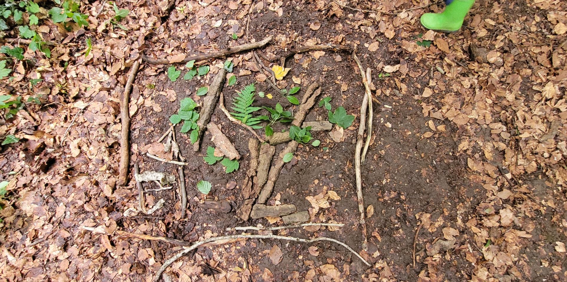 Aus Blättern und Stöcken legen wir wunderschöne Bilder auf dem Waldboden.