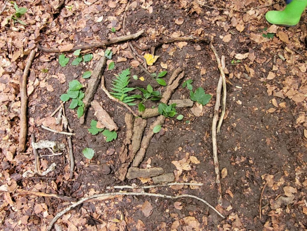 Aus Blättern und Stöcken legen wir wunderschöne Bilder auf dem Waldboden.
